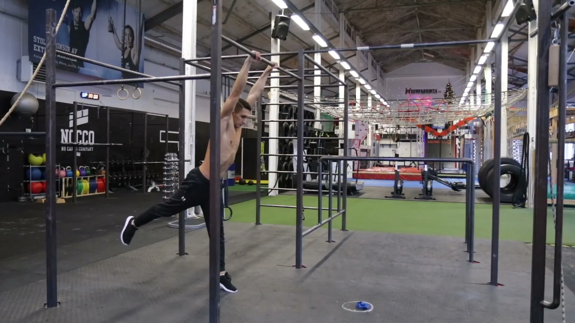 Kick-up phase of the dynamic muscle up with straight legs rising toward the bar after the power button loading