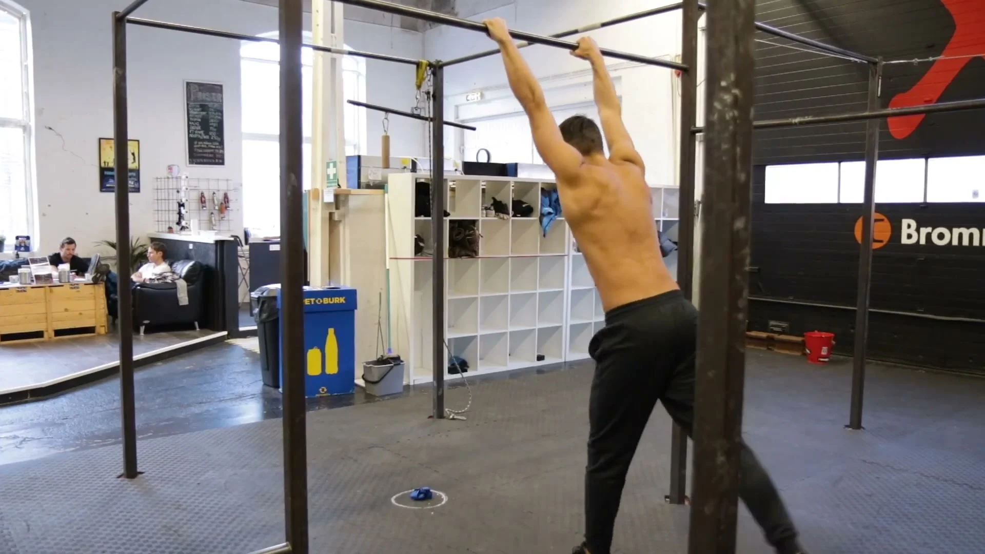 Pressing the power button position in the dynamic muscle up swing, body fully extended and loaded before the kick