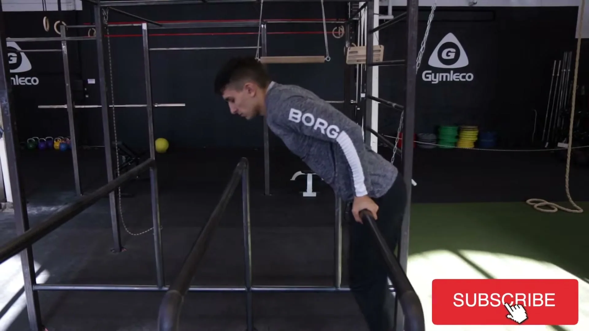 Full jump in completion on parallel bars, body between the bars after the jump with hands catching the bars