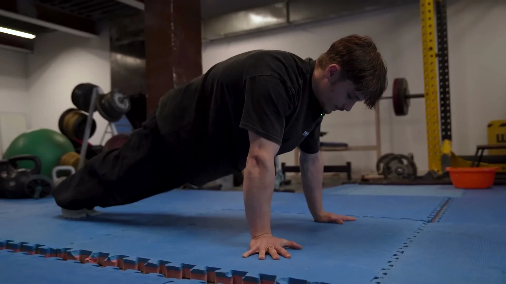 Nathan Bosech in lean planche position with rounded back and weight shifted forward over hands