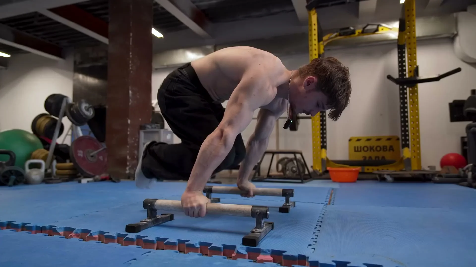 Nathan Bosech in tuck planche position with hips close to hands and feet fully off the ground