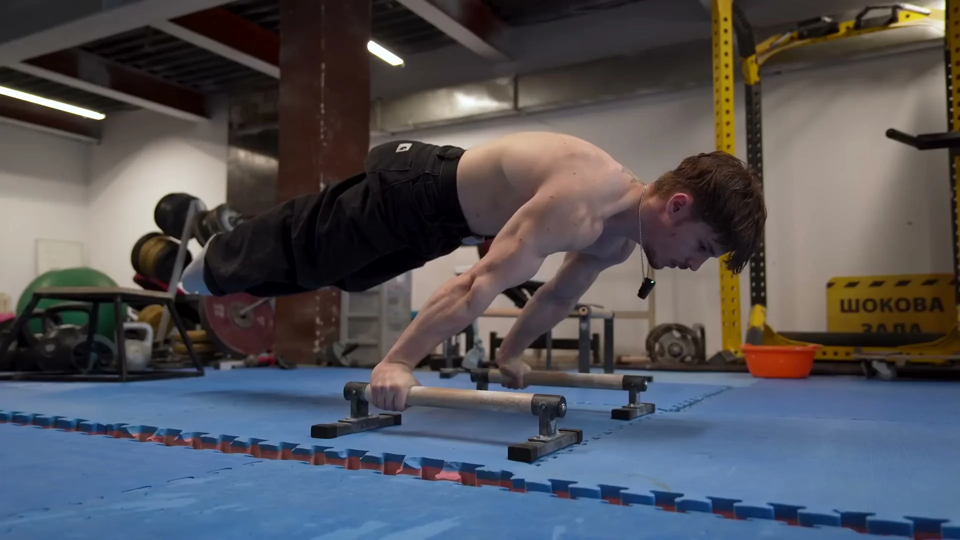 Nathan Bosech performing a tuck to planche with straight arms on calisthenics bars