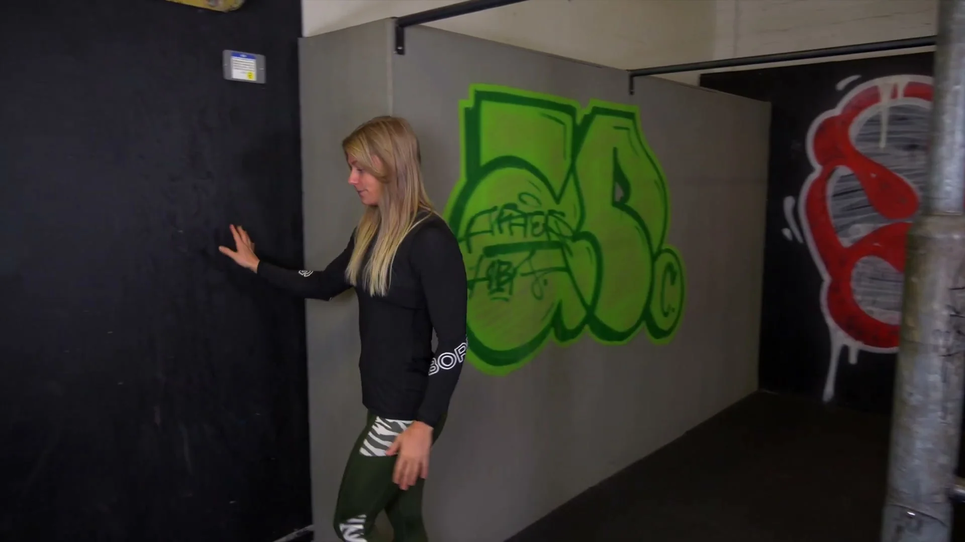 Toes to bar on a wall bar or free bar for V-sit training: legs lifting as high as possible with compression active, wall bar version preventing backward lean