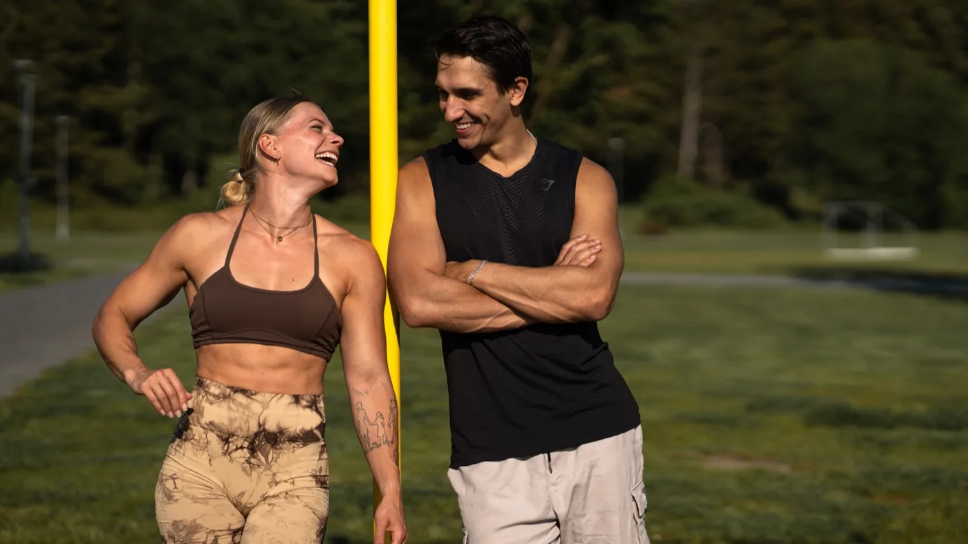 Daniel Flefil and Malin Malle Jansson laughing together at an outdoor calisthenics park